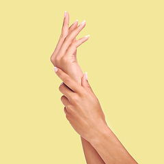 Image showing Skincare, yellow background and hands of woman in studio for wellness, cosmetics and manicure treatment. Spa aesthetic, beauty salon and isolated palms of girl apply lotion, nail cream or moisturizer