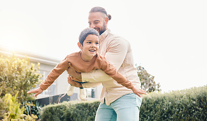 Image showing Carefree, flying and playing father with a child in a garden for freedom, play and bonding. Happy, laughing and dad holding a boy kid to fly while enjoying time in the backyard of a house together