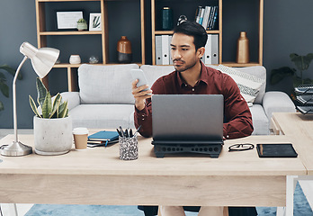 Image showing Asian man, phone and texting in office for email communication, corporate schedule and laptop. Entrepreneur, businessman or focus with smartphone for networking, tech and web chat app with digital ux