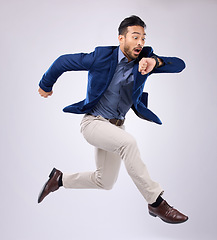 Image showing Wristwatch, jump and Asian man late, appointment and employee against a grey studio background. Male manager, consultant and employee with schedule, deadline and stress with clock, jump and movement