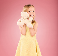 Image showing Teddy bear, girl and portrait with a soft toy with happiness and love for toys in a studio. Isolated, pink background and a young female child feeling happy, joy and cheerful with stuffed friend