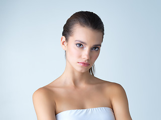 Image showing Beauty, skincare and serious face of woman in studio isolated on blue background in salon makeup. Cosmetics, portrait of model from Spain and spa facial treatment for fresh clean skin with mockup.