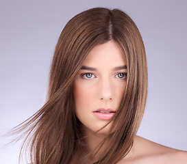 Image showing Portrait, hair and wind with a model woman in studio on a gray background for haircare or keratin treatment. Shampoo, salon and beauty with an attractive young female posing in a breeze on a wall