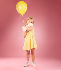 Image showing Teddy bear kiss, balloon and girl portrait with a soft toy with happiness and love for toys in a studio. Isolated, pink background and a young female child feeling happy, joy and cheerful with friend