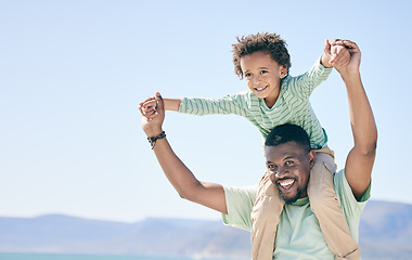 Image showing Black family, man and a son sitting on shoulders while outdoor in nature together during a beach vacation. Love, sky or kids with a father or parent carrying his child while walking on the coast