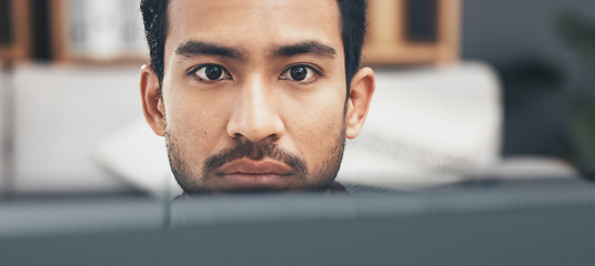 Image showing Face, focus and a business man at work on a computer in his office closeup for the company mission. Eyes, mindset and serious with a young male employee working on a desktop pc for administration