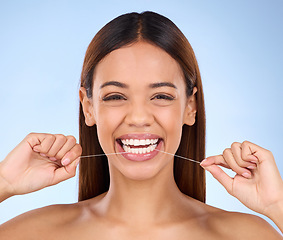 Image showing Dental floss, happy portrait and woman smile with teeth hygiene, healthcare and wellness treatment. Isolated, blue background and studio with a female feeling beauty from a clean mouth with self care