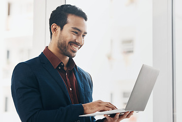 Image showing Corporate asian man, laptop typing and smile in office for email communication, chat or social media. Entrepreneur, businessman and happy with computer for web design, chat or funny meme on internet