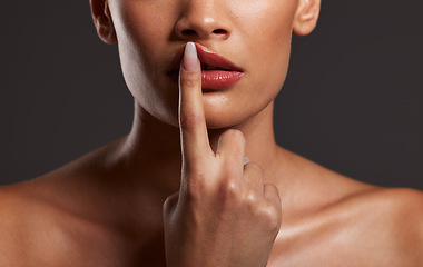 Image showing Finger, lips and beauty with a model woman in studio on a gray background for skincare or cosmetics. Hand, makeup and mouth with a female touching her lip to promote a lipstick or cosmetic product