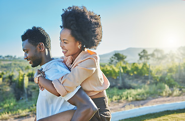 Image showing Love, black couple and piggy back in countryside, travelling and bonding for vacation, relationship and break. Romance, man carry woman and loving on weekend, holiday and honeymoon to relax and smile