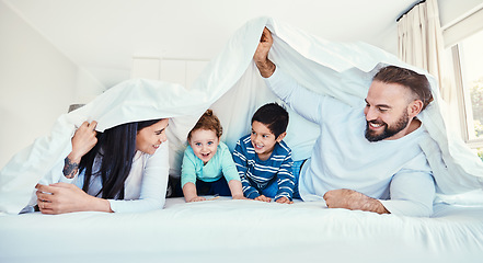 Image showing Family, blanket and fun by children and parents in bed, happy and smile while playing and bonding in their home. Bedroom, fort and kids with mother and father, waking up and enjoying weekend indoors
