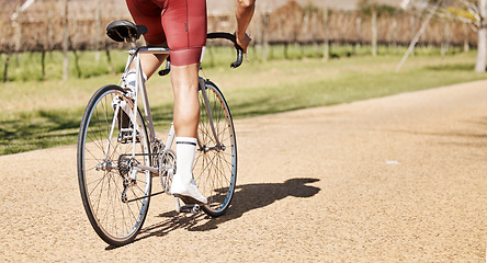 Image showing Back of man, bicycle and path in park, exercise and training of triathlon sports in sunshine. Cyclist legs, bike and outdoor cycling trail for freedom, cardio fitness adventure and performance mockup