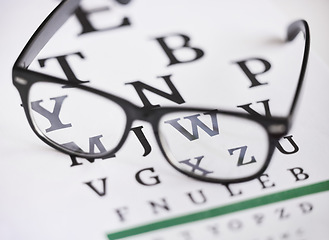 Image showing Optometry, letter and healthcare with glasses and chart for focus, reading and eye test. Medical, optics and prescription with spectacles on text paper graph for myopia, sight and vision exam