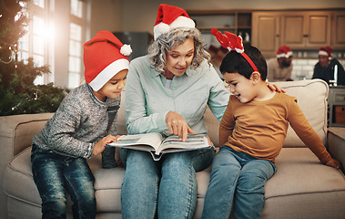 Image showing Christmas, photo album or children with a senior woman and kids looking at photographs during festive season. Family, love or celebration with a grandmother and grandchildren holding a picture book