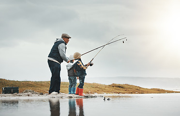 Image showing Lake, outdoor and grandfather fishing with children while on a adventure, holiday or weekend trip. Hobby, travel and elderly man teaching kids to catch fish in nature while on vacation in countryside