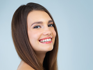 Image showing Hair, beauty and portrait of woman with smile on blue background for wellness, skincare and spa treatment. Salon aesthetic, dermatology and face of happy girl with cosmetics, makeup and facial glow