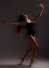 Image showing Art, dance and woman in the dark for ballet isolated on a black background in a studio. Creative, elegant and contemporary dancer dancing for a theater performance, rehearsal or ballerina movement