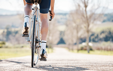 Image showing Back of man, bike wheel and park path for fitness, training and triathlon sports in sunshine. Legs, cycling and bicycle on road for outdoor exercise, power and performance action with summer freedom