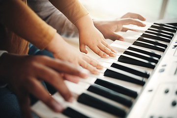 Image showing Hands, parent and child playing piano as development of skills together and bonding while making music in a home. Closeup, musical and kid learning a song on an instrument and father teaching