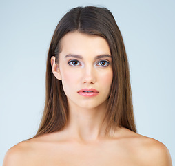 Image showing Portrait, beauty and woman with makeup, skincare and self care and glow or soft skin isolated in studio blue background. Face, headshot and serious clean female model for cosmetic health