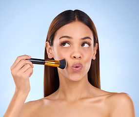 Image showing Beauty, makeup and brush with woman in studio for cosmetics, satisfaction and self care. Glow, foundation and blush with girl model on blue background for facial, powder and cosmetology product