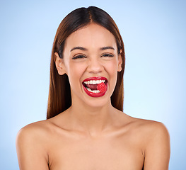 Image showing Beauty, health and raspberry with woman in studio for nutrition, diet and detox. Organic food, natural cosmetics and self care with girl model eating fruit on blue background for wellness and glow