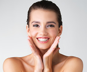 Image showing Happy, woman and hands on face in studio for makeup, wellness or cosmetic on grey background. Portrait, smile and girl beauty model with dermatology, satisfaction or luxury routine while isolated