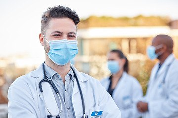 Image showing Face mask, covid doctor and man portrait outdoor with arms crossed for medical and health insurance. A happy healthcare worker with ppe for corona virus safety and compliance for wellness and help