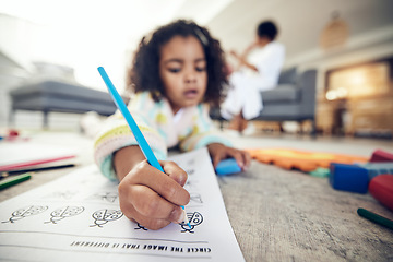 Image showing Child hand, coloring homework and pencil art of a girl lying on a living room carpet at home. House, color learning and creative development activity of young kid in kindergarten with a school book