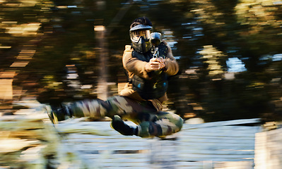 Image showing Action, paintball and man shooting and jumping on battlefield with a gun in a game, match or training. Shooter, blur motion and male with strategy in military aim and shoot target outdoors