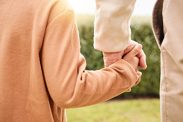 Image showing Kid, park and holding hands with parents on vacation, adventure walk or freedom in nature together. Young child child, outdoor happiness or holiday for helping hand, support and walking in sunshine