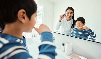 Image showing Happy family, woman and boy in bathroom for brushing teeth, healthcare and bonding to start morning in house. Young kid, mother and teaching with toothbrush, smile and mirror for medical self care