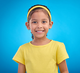 Image showing Happy, smile and portrait of girl in studio for natural, youth and confident isolated on blue background. Happiness, break and positive with face of young child for cute, adorable and trendy style