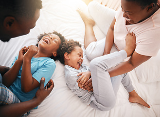 Image showing Tickle, funny and relax with black family in bedroom for bonding, playful and affectionate. Laugh, happiness and crazy with parents playing with children at home for wake up, morning and silly