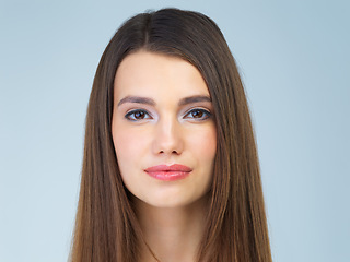 Image showing Hair, beauty and portrait of woman with makeup, cosmetics and skincare products on blue background. Salon aesthetic, dermatology and face of girl in studio for wellness, spa treatment and facial care