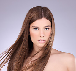 Image showing Portrait, hair and breeze with a model woman in studio on a gray background for haircare or keratin treatment. Shampoo, salon and beauty with an attractive young female posing in a wind on a wall