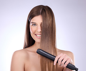 Image showing Hair straightener, face portrait and beauty of woman in studio isolated on a gray background. Haircare, happy and female model with flat iron product for salon treatment, balayage and hairstyle.