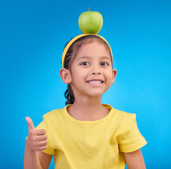 Image showing Happy, portrait and a young girl with a thumbs up isolated on a blue background in a studio. Review, success and face a child with a hand gesture for satisfaction, emoji and agreement on a backdrop