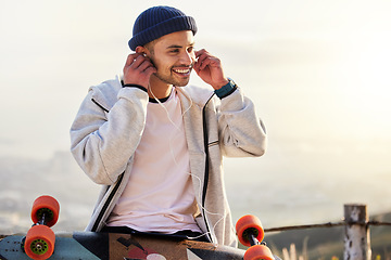 Image showing Skateboarder, earphones and man listening to music, audio or podcast online and relax after skating outdoors. Skater, skateboard and person streaming to mobile radio and texting on social media