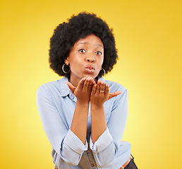 Image showing Happy, blowing kiss and portrait of black woman in studio for confidence, flirting and romance. Self love, relax and desire with female on yellow background for positive, sensual and proud gesture