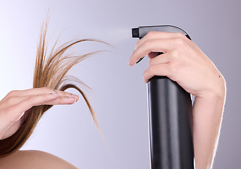 Image showing Hair care, beauty and hands with spray in studio isolated on a gray background. Cosmetics product, keratin and model woman with hairspray bottle for salon treatment, growth and hairstyle moisturizer.