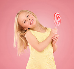 Image showing Candy, happy and lollipop with portrait of girl in studio for sugar, party and carnival food isolated on pink background. Cute, positive and youth with child and eating snack for playful and treats