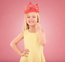 Image showing Girl, child and smile portrait with a crown in studio on a pink background with smile and prop. Female princess kid model with happiness, creativity and royal icon in hand isolated on color and space