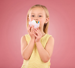 Image showing Girl child, cupcake and portrait in studio on a pink background while eating cake. Face of a female kid model with a sweet snack, creativity and paper in hand isolated on color and a gradient space