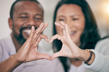 Image showing Hands, love and heart with a couple in their home to relax together in the living room closeup. Hand gesture, emoji or romance with a senior man and woman bonding while sitting in their house