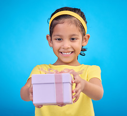 Image showing Box, present and girl with smile, excited and cheerful against a blue studio background. Female child, kid and young person with gift, package and happiness with joy, excitement and product promotion