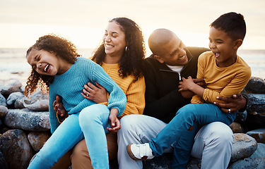 Image showing Laughing, family and relax at beach on vacation, holiday or trip at sunset outdoors. Love, care and happy, bonding and funny children, father and mother with laughter for tickling, joke or comedy.