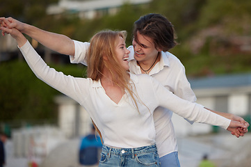 Image showing Freedom, happy and laughing couple at the beach for a date, honeymoon and bonding in Bali. Smile, flying and playful man and woman with care, love and affection at the sea for happiness together