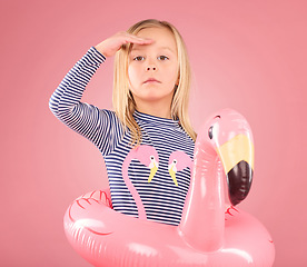 Image showing Safety, search and portrait of girl and pool float for swimming, summer break or cute. Youth, swimsuit and inflatable with child and flamingo ring for playful, beach and holiday on pink background