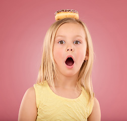 Image showing Child, wow and donut portrait in studio with surprise on head on a pink background. Face of a girl kid model with mouth open, shocked and comic chocolate snack isolated on creative color and space